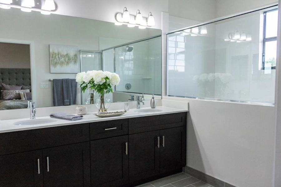 Salle de bain noire avec poignée, double vasque, offrant une esthétique élégante et contemporaine. Le noir crée une ambiance sophistiquée et intemporelle par L. Cuisine et Aménagement