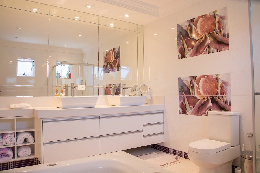 Salle de bain sur mesure blanche avec poignée grise, double vasque et immense miroir offre une esthétique moderne et épurée. Le contraste entre le blanc et le gris crée une ambiance sophistiquée et contemporaine par L. Cuisine et Aménagement sur Nîmes et Montpellier. .