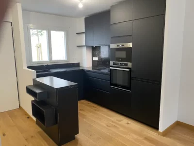 Cuisine sur mesure compacte en noir avec un plan de travail en noir imitation marbre, offrant une esthétique élégante et luxueuse. Malgré sa taille réduite, cette cuisine offre un espace de travail fonctionnel et stylé par L. Cuisine et Aménagement sur Nîmes et Montpellier.